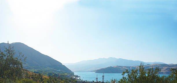 There are mountains and houses on the water's edge