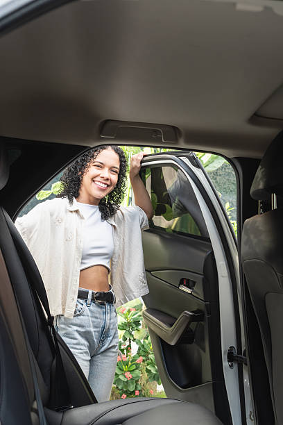 istock Woman smiling getting into a car and traveling 2244123645