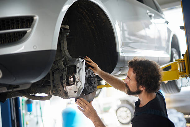 istock Mechanic examining car brakes in a professional workshop 2244124126