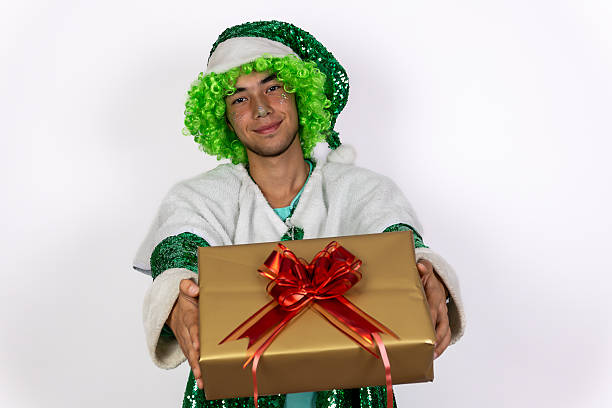 A Christmas elf is holding out a wrapped gift.