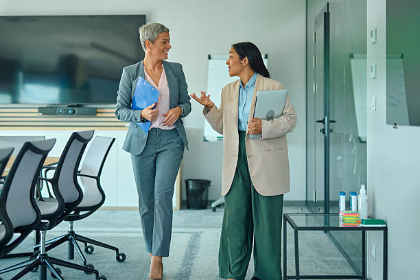 istock Businesswomen walking and talking in modern office 2244127617
