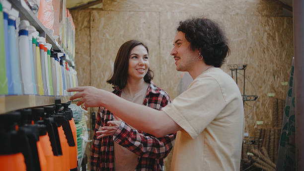 istock Two friends share smiles while exploring a vibrant greenhouse filled with various gardening tools and plants, enjoying their shopping experience on a sunny day. 2244130533