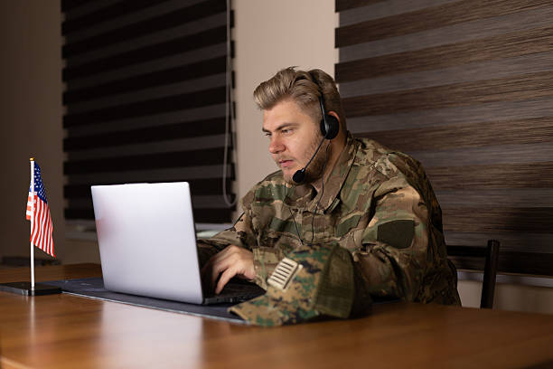 istock Man in military uniform uses laptop inside armored vehicle, 2244133211