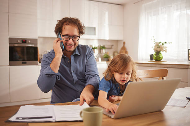 istock Father multitasking working from home with daughter on laptop 2244135327