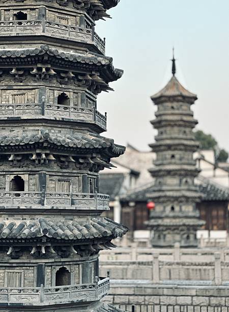 Close-up details of the historic twin pagodas in Nanxiang Ancient Town, Shanghai, showcasing intricate ancient Chinese architecture with tiled roofs and ornate eaves against a soft sky. Ideal for cultural heritage photography, travel designs, or traditional Asian themes.