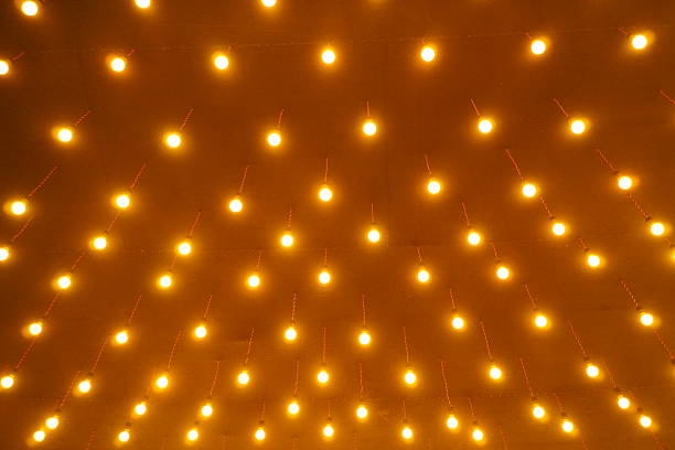 istock ceiling installation featuring numerous incandescent light bulbs hanging down on individual wires. 2244140092