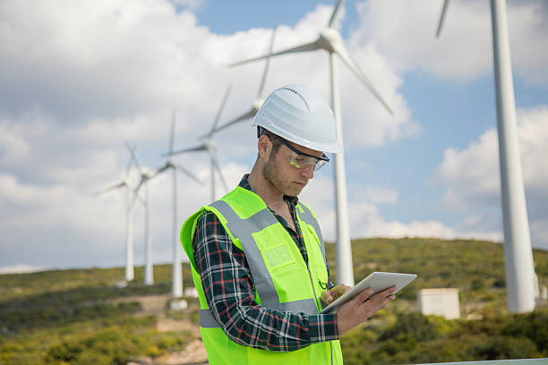 istock Engineer Man Using Digital Tablet for Wind Turbine Inspection at a Wind Farm for Renewable Energy Projects 2244141928
