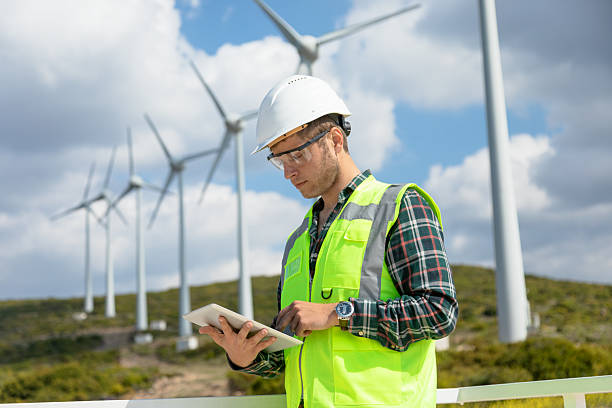 istock Engineer Man Using Digital Tablet for Wind Turbine Inspection at a Wind Farm for Renewable Energy Projects 2244141933
