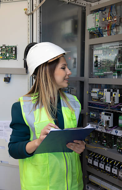 istock Female Electrical Engineer Performing Technical Inspection and Recording Data in Modern Control Room of Renewable Energy Facility 2244141968