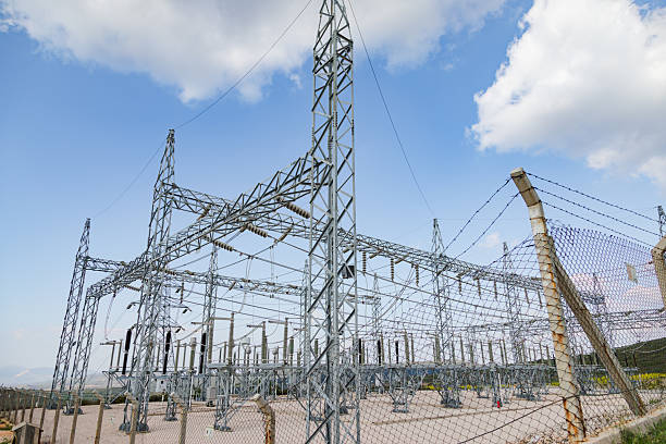 A modern high-voltage electrical substation featuring intricate steel frameworks, insulators, and transmission lines under a partly cloudy sky. The facility represents advanced energy infrastructure integrating AI-powered systems for real-time monitoring, automation, and efficient electricity distribution in renewable and smart grid networks