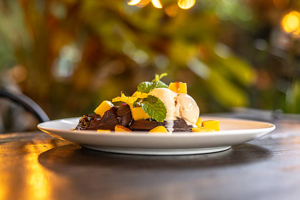 Brownie waffle is serving with tropical fruits and vanilla ice cream.