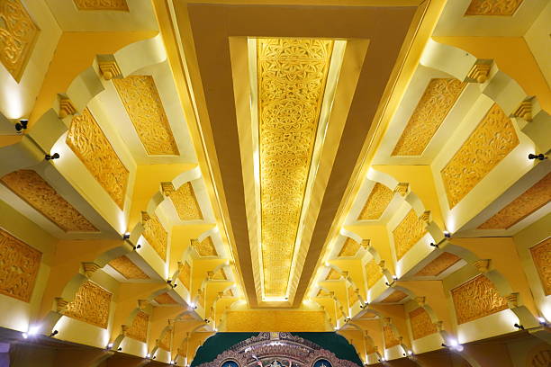 Ornate golden ceiling with recessed lighting in symmetrical interior perspective view