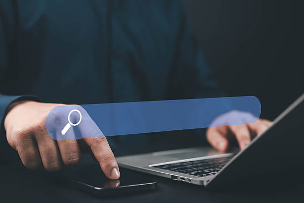 istock Businessman using laptop and smartphone with digital search bar, symbolizing SEO, online marketing, web browsing, and internet technology in modern business concept marketing, and digital 2244144319