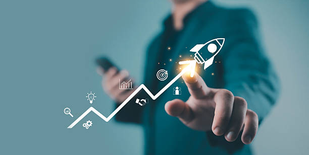 istock Businessman pointing at rocket icon on growth graph, symbolizing startup success, innovation, progress, business growth, and modern digital marketing strategy glowing digital 2244144457