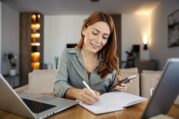 istock Woman working from home, multitasking with laptop and phone 2244145752