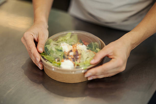 istock Hands preparing fresh salad in eco-friendly container for take-out 2244146908