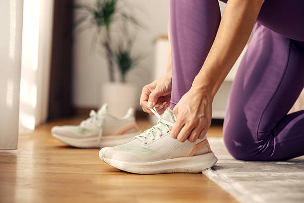 istock Woman tying shoelaces getting ready for home workout 2244147447