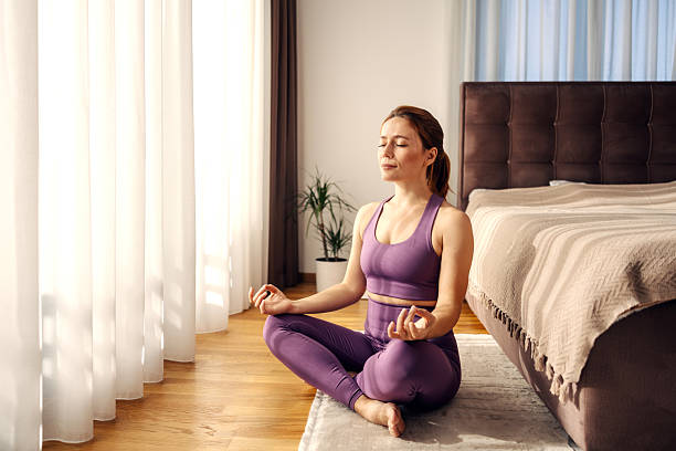 istock Woman meditating in lotus pose for mindfulness at home 2244147611