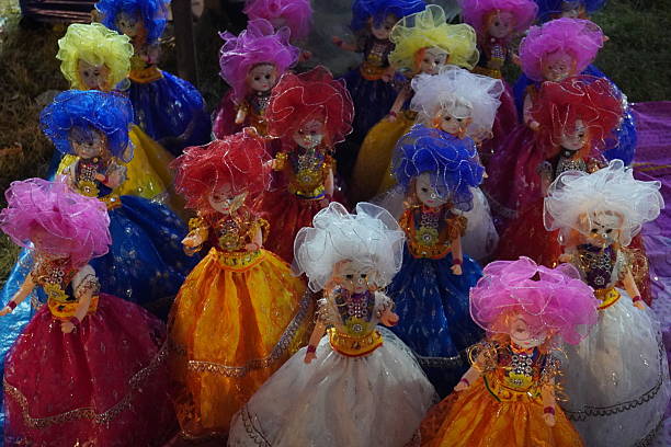 Vibrant plush dolls, dressed in bright costumes, hanging on a display during the Camel Fair in Pushkar, Rajasthan, India. Capturing the festive and artistic atmosphere of the fair.