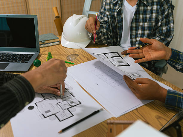 istock Architects working with blueprints at their desks. Architectural concept drawings, sketches and construction models. Close-up. 2244154276