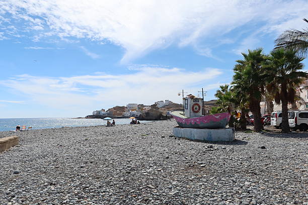 San Miguel de Tajao, Tenerife, Spain, October 26, 2025: Old fishing boat on the rocks beach of Tajao, Tenerife, Spain