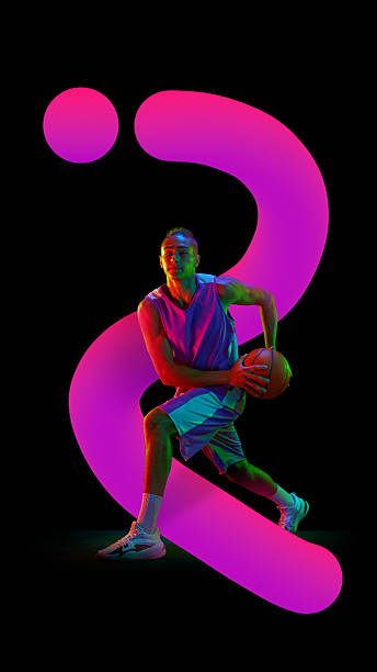 istock Graphic composition. Basketball player in pink neon arc with intense focus on black background 2244156628