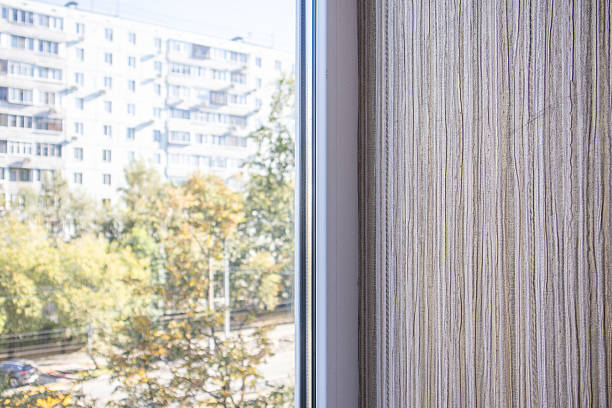 istock Textured beige wall by window city view and trees soft daylight horizontal frame 2244157586