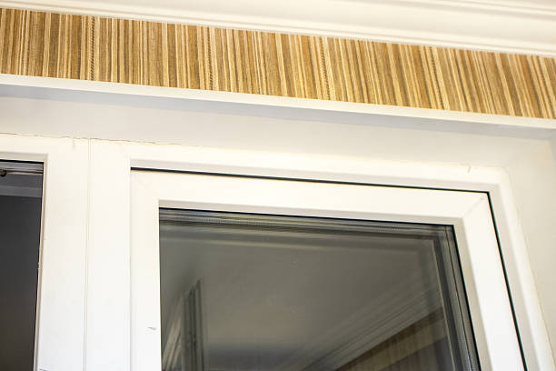 istock White PVC window frame and striped wallpaper with crown molding close up 2244157589