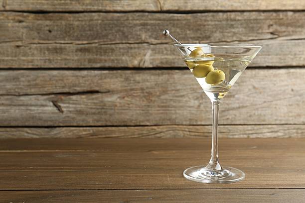 istock Martini cocktail with olives in glass on wooden table, space for text 2244157746
