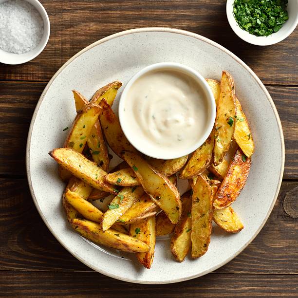 istock Baked potato wedges with sauce 2244158386