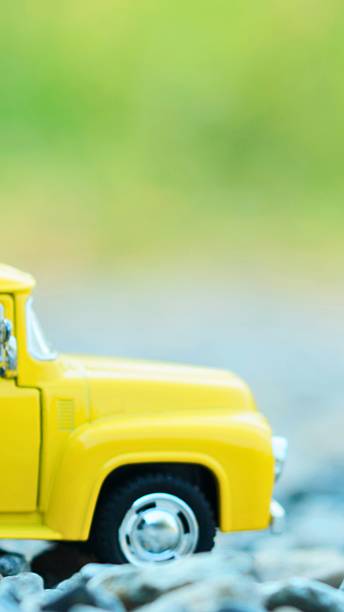 istock Bright yellow toy pickup truck on a textured surface 2244158616