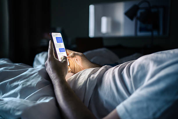 istock Phone in bed. Text message. Man texting. Screen time at night. Using smartphone messenger app in dark bedroom or hotel room before sleeping. 2244159658