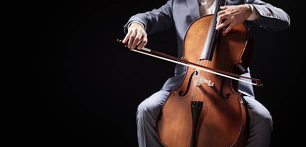 istock Cello player cellist performing in an orchestra black background 2244160145