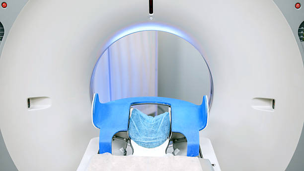 CT scanner with a blue patient bed and soft fabric cover, illuminated by ambient light, showcasing advanced medical imaging technology for x-ray diagnosis