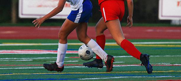 Soccer Players Competing on the Field During an Evening Match