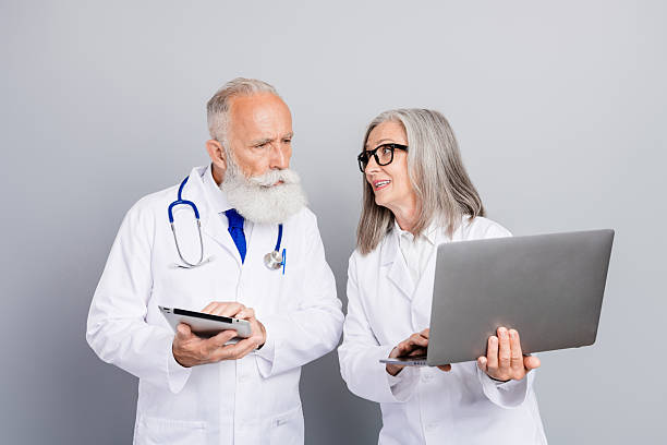 istock Two experienced doctors discuss patient care using tablet and laptop during a professional consultation in a clinical setting 2244166943