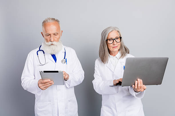 istock Two experienced doctors review patient information using tablet and laptop in a modern clinic setting 2244166986