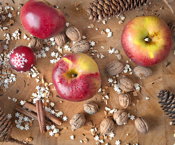 istock cinnamon sticks and bright red apples covered by drops with pine cone and christmas ball and spices spilled on a plank still life winter and holidays food ingredient 2244167844