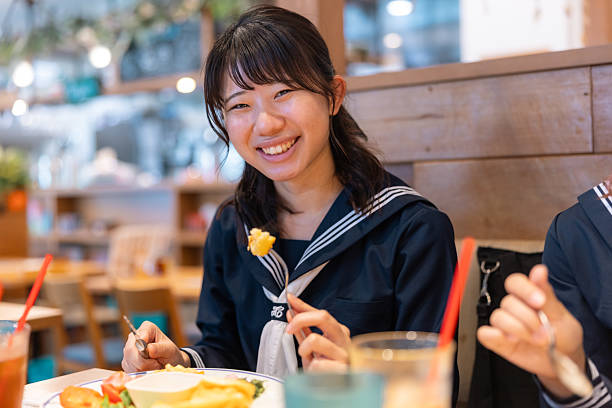Female high school student having lunch in cafe - looking at camera