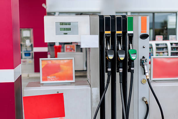 A modern gas pump at a fuel station, showing several fuel nozzles, digital price display, and clean service area.