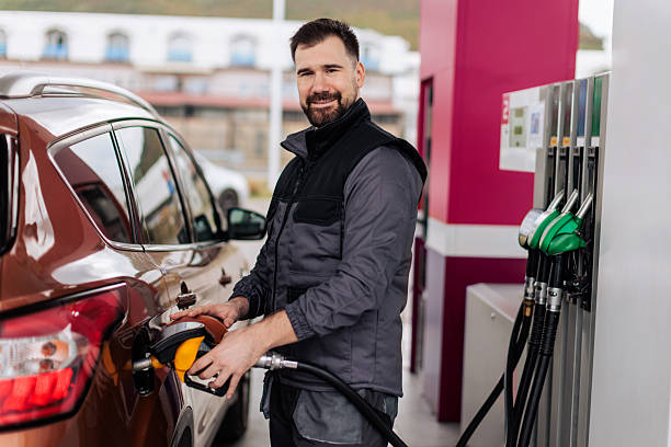 istock Smiling Gas Station Attendant Refueling Car 2244177160