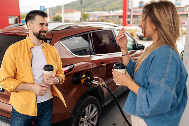 istock Couple Enjoying Coffee While Refueling Their Car 2244178659