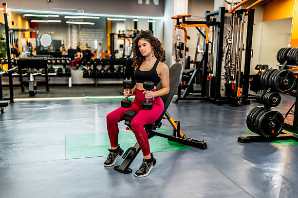 istock Young woman training with dumbbells in gym 2244178884