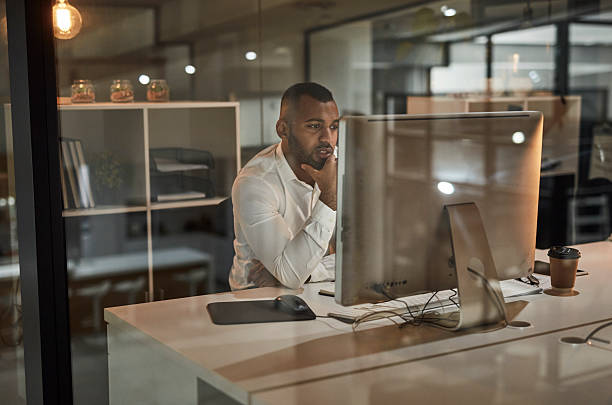 istock Thoughtful Business Professional At Desktop Computer In Modern Office Through a Glass Wall 2244179653