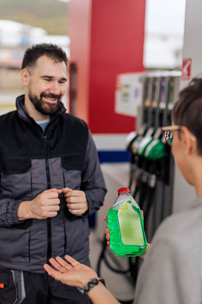 istock Gas Station Worker Helping Woman Pick Windshield Cleaner 2244180067