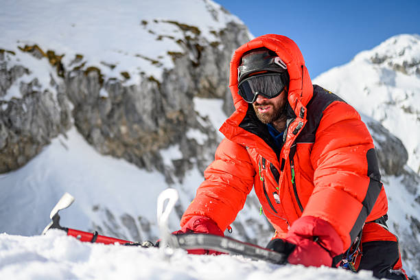 istock Climber Adjusting Equipment on Snowy Mountain Slope 2244180504