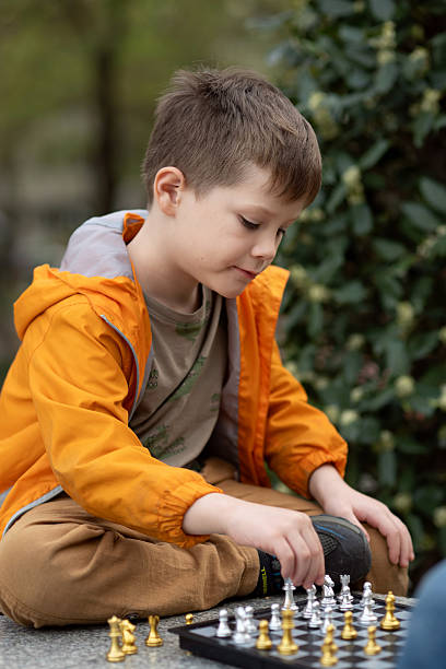 istock Boy playing chess outdoor. Learning strategic game. Education. 2244180575