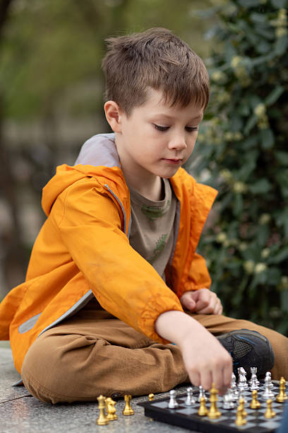 istock Boy playing chess outdoor. Learning strategic game. Education. 2244180604