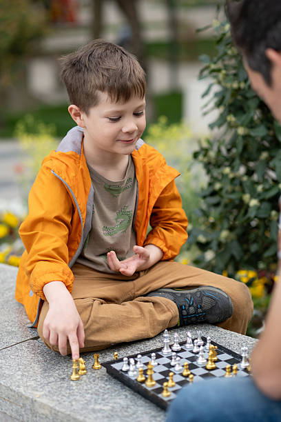 istock Boy playing chess outdoor. Learning strategic game. Education. 2244180606