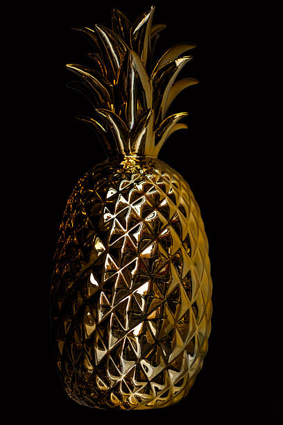 istock Golden pineapple texture. Golden pineapple on black background with luxury metallic texture. Decorative pineapple symbol of wealth and tropical luxury. 2244190180